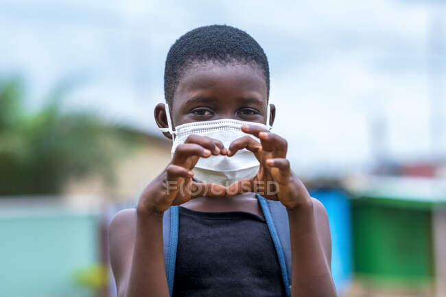 Girl in face mask making heart sign. — Stock Photo