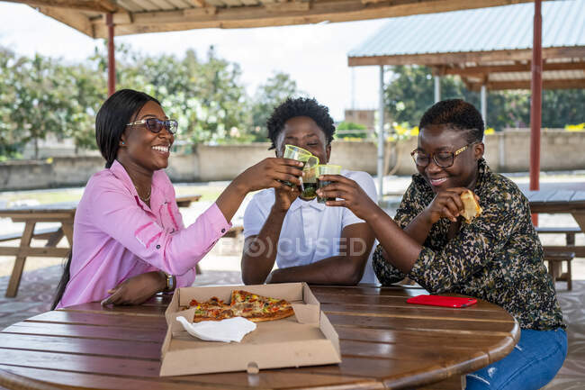 Friends toasting over pizza. — Stock Photo