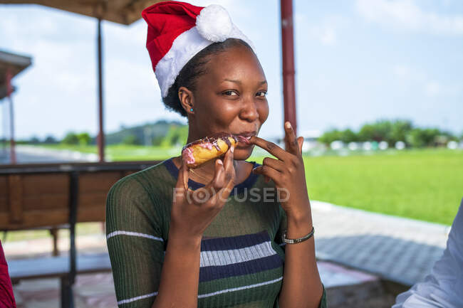 Woman eating dessert in a Santa hat. — Stock Photo