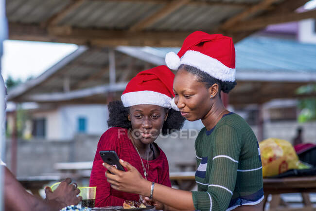 Smiling friends looking at a smartphone. — Stock Photo