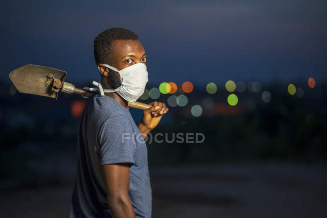 Man in face mask with shovel. — Stock Photo