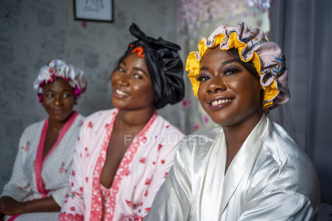 Happy women in dressing gowns and hair bonnets. — Stock Photo