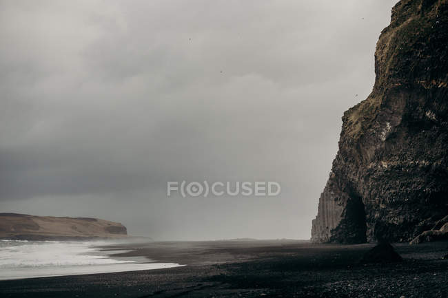 Черный песок базальтовый пляж и скалы — стоковое фото