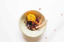 Fruit compote in bowl with merigold flowers — Stock Photo