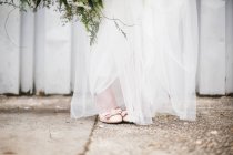 Noiva de pé em vestido vestindo — Fotografia de Stock