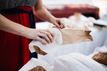 Mulher colocando pão no saco de papel — Fotografia de Stock
