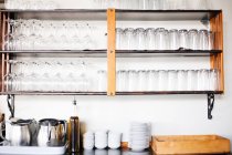 Glasses on shelves and tableware — Stock Photo