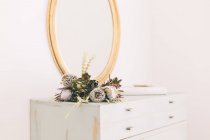Floral arrangement on dresser — Stock Photo