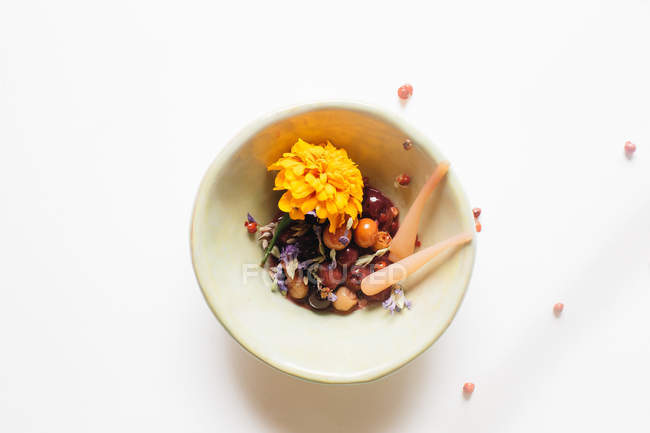 Composta di frutta in ciotola con fiori di merigold — Foto stock