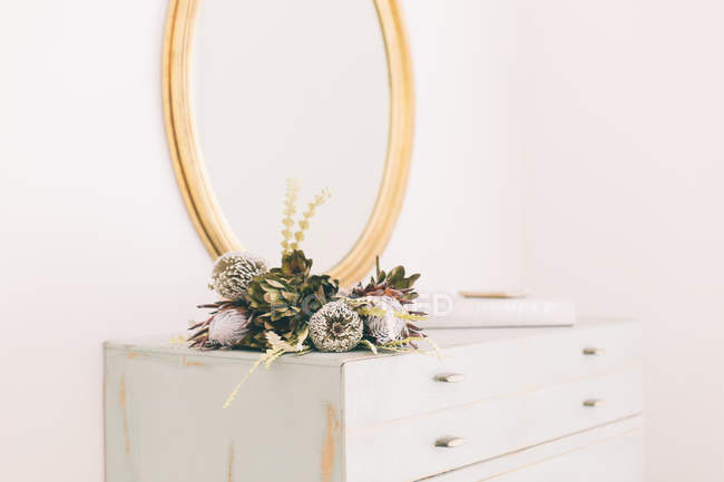 Floral arrangement on dresser — Stock Photo