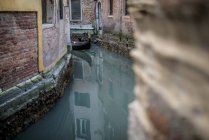 Gondola sailing on waters of Venetian channel — Stock Photo