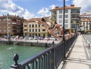 Two young girls jump off a bridge — Stock Photo