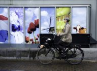 Ámsterdam, Países Bajos - 18 de junio de 2016: vista lateral de la mujer en bicicleta de la ciudad - foto de stock