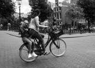 Ámsterdam, Países Bajos - 18 de junio de 2016: madre e hijo en bicicleta - foto de stock
