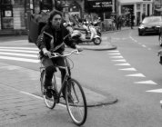 Amsterdã, Holanda - 18 de junho de 2016: homem com mochila grande andando de bicicleta na rua Amsterdã — Fotografia de Stock