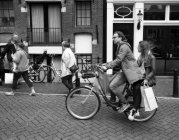 Amsterdam, Netherlands - June 18, 2016: side view of couple ridding on bike — Stock Photo