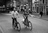 Amsterdam, Netherlands - June 18, 2016: people happily ridding on bicycles on street of Amsterdam — Stock Photo