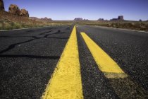 Strada statale che attraversa pianure aride della Monument Valley — Foto stock