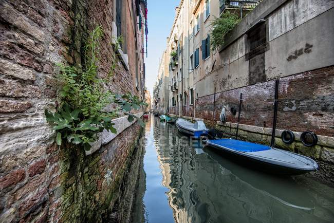 Canal with boats anchored along wall — Stock Photo