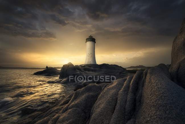 Lighthouse, water waves and rocks — Stock Photo