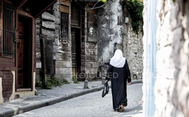 Woman walking down street — Stock Photo