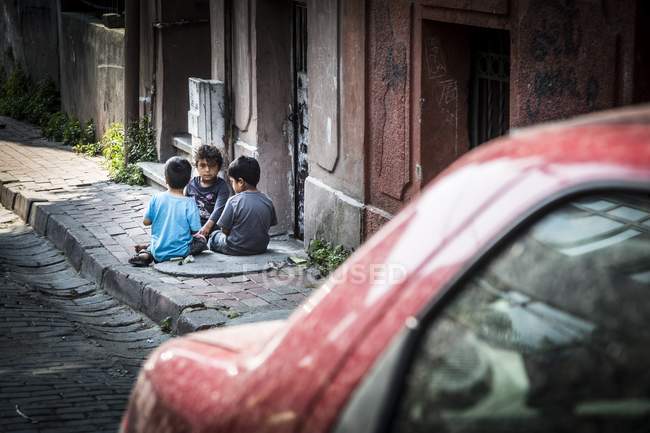 Kinder sitzen auf der Straße und spielen — Stockfoto