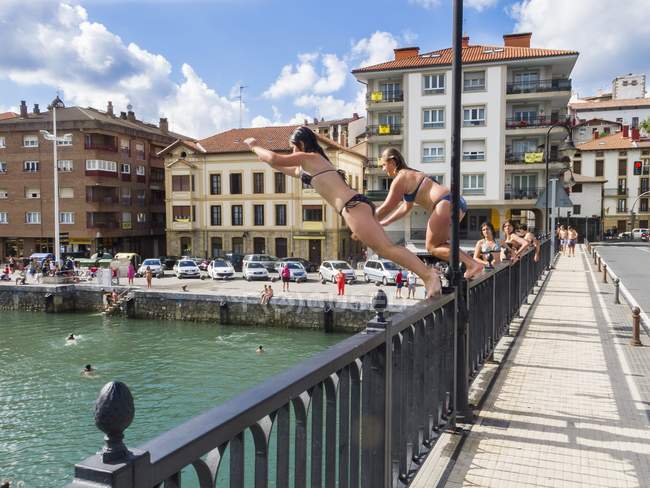 Zwei junge Mädchen springen von einer Brücke — Stockfoto