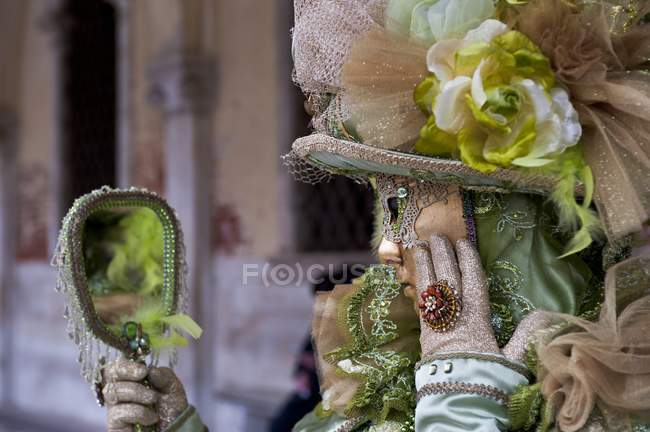Художник в традиционной маске смотрит в зеркало — стоковое фото