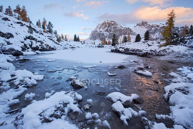 Lago de agua clara, árboles y laderas nevadas - foto de stock