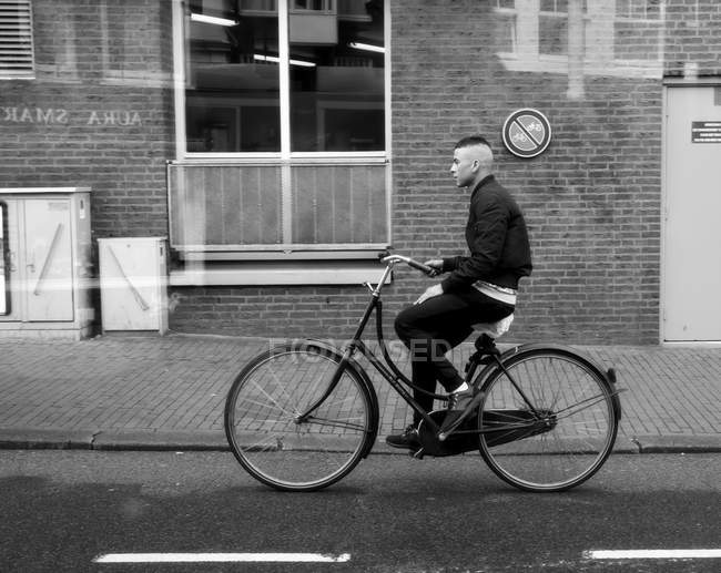 Ámsterdam, Países Bajos - 18 de junio de 2016: vista lateral del hombre en bicicleta - foto de stock