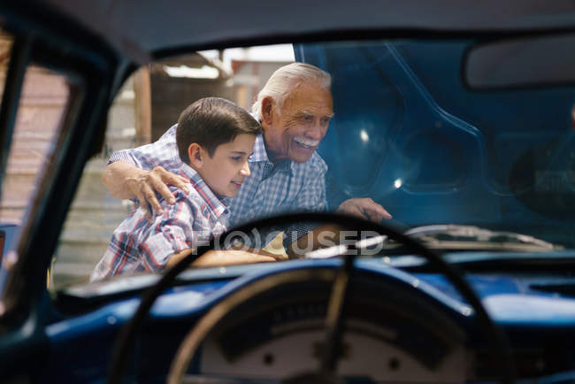 Junge mit Opa sucht Automotor des Seniors — Stockfoto