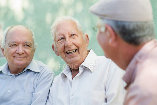 Grupo de homens idosos felizes rindo e conversando — Fotografia de Stock