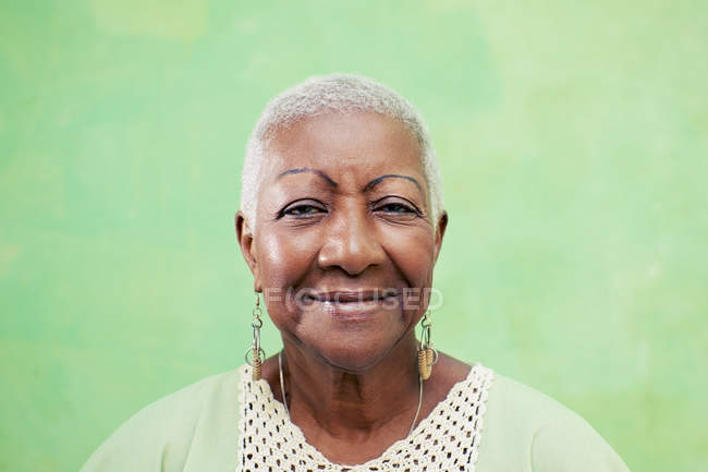 Retrato de mulher negra sênior sorrindo para a câmera em verde backgr — Fotografia de Stock