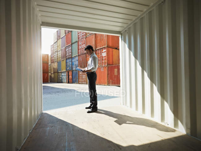 Business man with shipping containers — Stock Photo