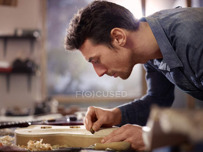 Italienischer Kunsthandwerker arbeitet in Lautenmacherwerkstatt — Stockfoto