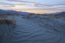 Puesta de sol sobre dunas de arena - foto de stock