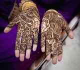 Primer plano de Mehndi cubriendo las manos femeninas - foto de stock