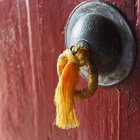 Pompon en or attaché à une poignée de porte — Photo de stock