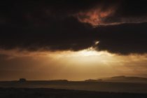 Luce del sole che splende attraverso nubi buie tempesta — Foto stock