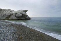 Пляж со скалой — стоковое фото