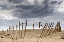 Clôture cassée Dans le sable — Photo de stock