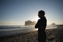 Giovane uomo stand sulla spiaggia — Foto stock