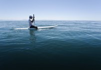 Vista laterale dell'uomo che remava su una tavola da surf — Foto stock