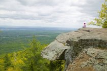 Одна женщина, сидящая на скале — стоковое фото