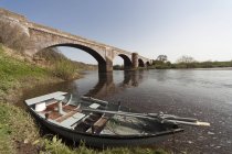 Boot am Ufer neben Brücke — Stockfoto