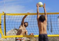 Двоє чоловіків грають у пляжний волейбол — стокове фото