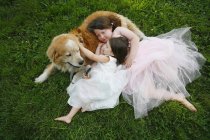 Zwei Schwestern umarmen Hund, — Stockfoto