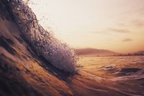 Большая волна в океане на закате — стоковое фото