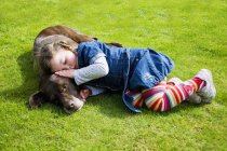 Petite fille endormie sur chien — Photo de stock