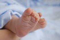 Vista primo piano ritagliato di nudi piedini bambino — Foto stock